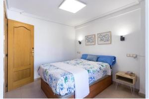 una piccola camera da letto con un letto con copriletto blu di Payma Apartments Benidorm a Benidorm
