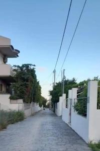 a cobblestone alley with a white fence and a street at Nàra house in Áyios Spirídhon