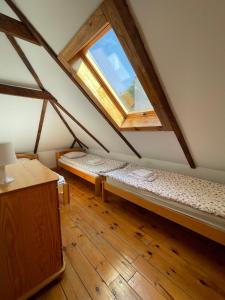 an attic room with two beds and a window at Domki nad strumykiem in Mirsk
