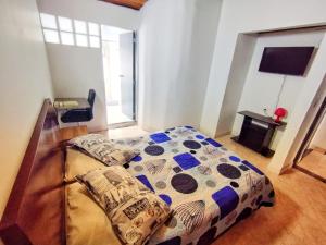 een slaapkamer met een bed, een bureau en een raam bij Aloha Hostel in Bogota