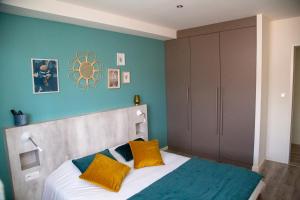 a bedroom with a bed with yellow and blue walls at LOGIS - Hôtel Restaurant Du Canard in Hangest-sur-Somme
