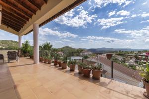 balcón con macetas y vistas a las montañas en 6 bedrooms villa with sea view private pool and jacuzzi at Olivella en Olivella