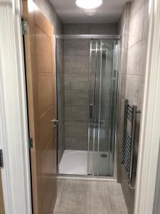 um chuveiro com uma porta de vidro na casa de banho em New one bed 1st floor flat close to the beach em Southbourne