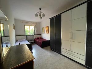 a living room with a bed and a large cabinet at Lovely spacious house with big garden in Elbasan