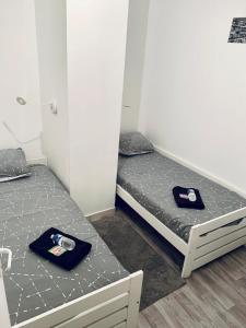 2 camas individuales en una habitación con toallas. en Appartement - 2 chambres - 4 personnes, en Denain