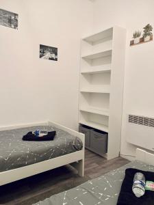 1 dormitorio con cama y estante para libros en Appartement - 2 chambres - 4 personnes, en Denain