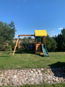 a playground with a slide and a swing at Privatus rąstinis namas su pirtimi in Dėckiai