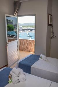 Duas camas num quarto com vista para uma varanda em Eco Hotel em Navegantes