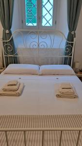 a bed with two towels on it with a window at Casina di Alice in Vinci