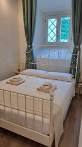 a bedroom with a bed with white sheets and a window at Casina di Alice in Vinci