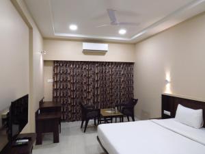 una camera d'albergo con letto e scrivania di City Palace Resort a Lonavala