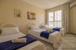um quarto de hotel com duas camas e uma janela em PRG143 - Próx Av Brasil, Garagem, 4 Dorm, Wi-Fi em Balneário Camboriú