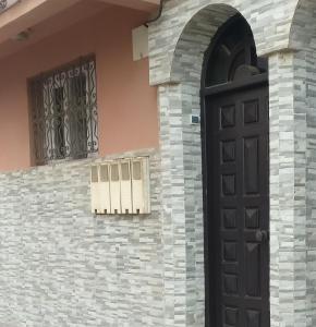 une entrée à une maison avec une porte noire dans l'établissement Araucaria, à Essaouira
