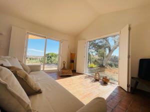 a living room with a couch and a large window at Corvatos Casas do Monte in Almodôvar