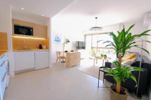 eine Küche und ein Wohnzimmer mit einem Sofa und einem Tisch in der Unterkunft Antibes centre, 2P refait à neuf, terrasse, garage in Antibes