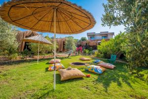 Kaş Joy Glamping في كاس: مجموعة من الوسائد على العشب مع مظلة