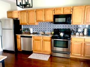 una cocina con armarios de madera y electrodomésticos de acero inoxidable en Fabulous Two Bedroom in Groton, en Groton