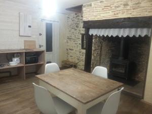 a dining room with a table and a fireplace at Chaleureuse petite maison avec jardin in Gagnac-sur-Cère