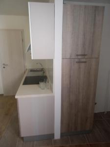 a kitchen with a sink and a wooden cabinet at Apartma Eli in Koper