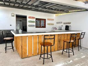 una cocina con encimera con taburetes alrededor en Villa des Pêcheurs Beach Hôtel, en Cap Skirring