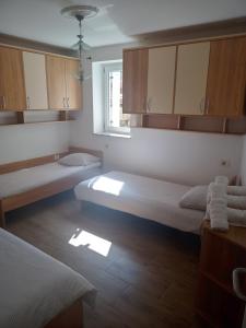 a small room with two beds and a window at Apartma Eli in Koper