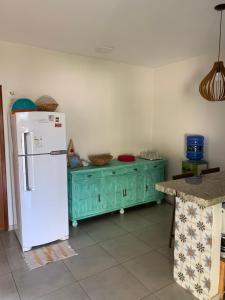 eine Küche mit einem weißen Kühlschrank und einem grünen Schrank in der Unterkunft Chalé Estrela da Barra in Barra Grande