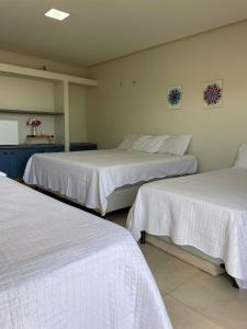 ein Zimmer mit zwei Betten mit weißen Laken in der Unterkunft Chalé Estrela da Barra in Barra Grande + 66 Fotos