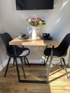 a wooden table with two chairs and a vase of flowers at 12 North Street in Sandwick