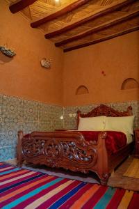 sypialnia z drewnianym łóżkiem w pokoju w obiekcie Maison etoile du desert w mieście Aït Boukha