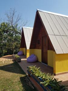 una casa con techo inclinado y almohadas moradas en una terraza en Chalés Magia das Águas, en Águas de Lindóia 36 fotos más