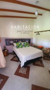 瓜塔佩的住宿－Casa Lucía - Guatapé，墙上有标牌的房间的一张床位