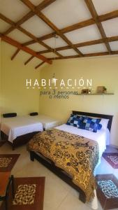 una habitación de hotel con 2 camas y un cartel en la pared en Casa Lucía - Guatapé, en Guatapé
