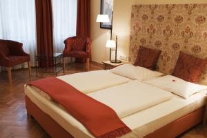 a hotel room with a bed, chair, and nightstand at Hotel Villa Florentina in Frankfurt