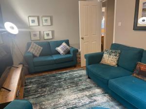 a living room with two blue couches and a table at Linmore in Aviemore