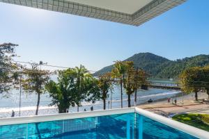 a view of the beach from the balcony of a resort at Ubatuba Praia Hotel in Ubatuba