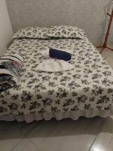 a bed with a flowery comforter on it at Pousada Don'Ana in Conde