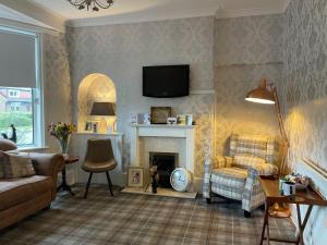 a living room with a couch and a fireplace at Gowanlea Guest House in Balloch