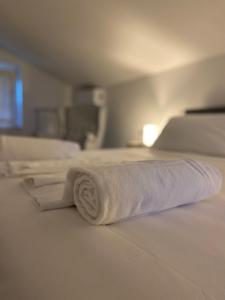- une serviette blanche roulée sur un lit dans l'établissement Tenuta Marina B&B, à Torino di Sangro