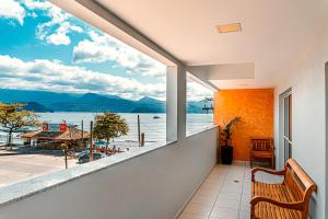 uma varanda com um banco e vista para a água em Ubatuba Praia Hotel em Ubatuba