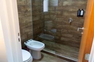 a bathroom with a shower with a toilet and a sink at Hotel Cantera Respira Campo in Potrero de los Funes