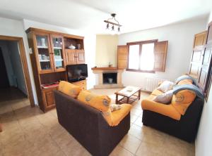 a living room with two couches and a tv at La Huertona in Pesaguero-La Parte