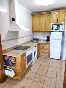a kitchen with wooden cabinets and a white appliance at La Huertona in Pesaguero-La Parte