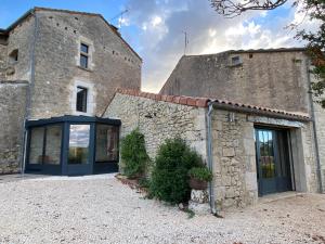 um grande edifício de pedra com uma porta azul em Maison de village, charme et confort em Mauroux