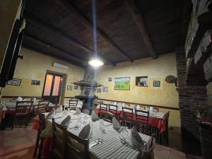 comedor con mesas y sillas y chimenea en Agriturismo Pingitore, en Luzzi