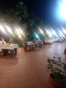 un grupo de personas sentadas en las mesas de noche en Agriturismo Pingitore en Luzzi