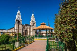 a gazebo in front of a church with two towers at QAIPU HOTEL in Puquio