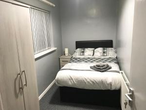 ein kleines Schlafzimmer mit einem Bett und einem Fenster in der Unterkunft Air Host in Walsall