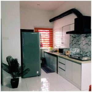 a kitchen with a green refrigerator and a potted plant at Homestay Ibu(Muslim sahaja) in Ipoh