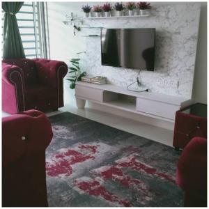 a living room with a television and two chairs at Homestay Ibu(Muslim sahaja) in Ipoh