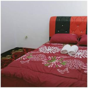 a red bed with two white towels on it at Homestay Ibu(Muslim sahaja) in Ipoh
